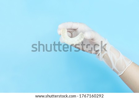 Hand in rubber medical gloves holding snap on smile,Natural Snaps On Teeth Cosmetic Secure Smile Instant Upper Veneers Dental  Royalty-Free Stock Photo #1767160292