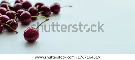 Banner with ripe cherries on a white background with place for text.