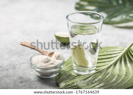 Collagen Powder and glass of water with  slice of Lime; Vitamin C . Collagen supplements may improve skin health by reducing wrinkles and dryness.