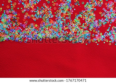 Multicolored shiny glitter confetti dots rain. Golden sparkling glittering border isolated on red background. Party tinsels shimmer, holiday background design, festive frame
