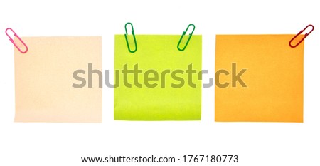 Colored pieces of paper with paper clips on a white background. For your text