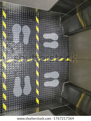 Selective focus to floor of passenger lift with standing marker for social distancing to avoid spreading coronavirus ( Covid-19 ). Location or distance concept. Idea for COVID-19 outbreak.