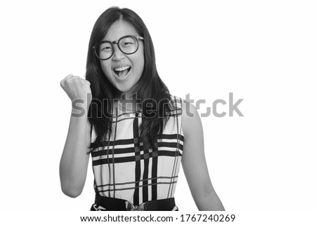 Portrait of happy young beautiful Asian businesswoman getting good news