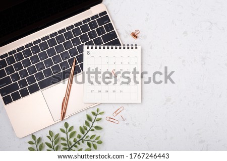 Calendar with rose gold pen on laptop on white quartz background with copy space, flat lay Royalty-Free Stock Photo #1767246443
