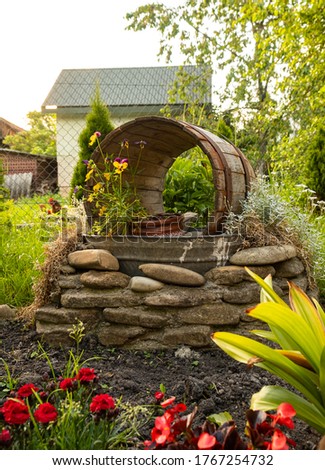 Picture of the garden. Wine tun is turned into a decoration element. Picture was taken in west part of Ukraine in June.