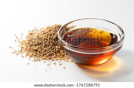 Sesame oil and sesame seeds on a white background Royalty-Free Stock Photo #1767288791