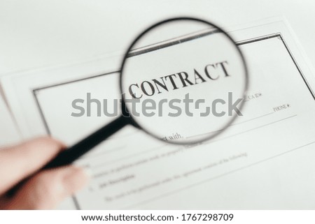 hand holds a magnifier. magnifier increases contract. White background. High quality photo
