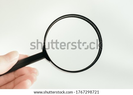 hand holds a magnifier. horizontal photo. business and finance. White background. High quality photo