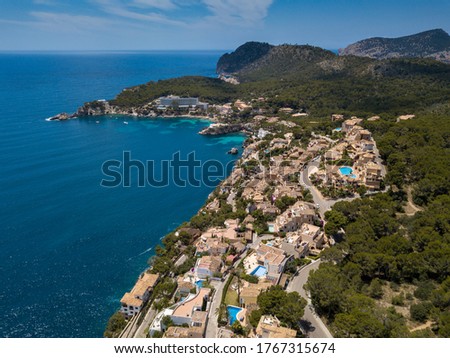 Aerial view to the green coastline with some houses and  blue water of Cala Fornells. Mallorca. Spain.