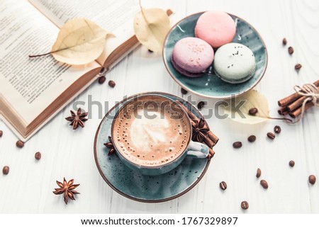 Coffee cup, macaroons and book on white background 