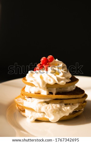 Banana pancakes with whipped cream and red currant