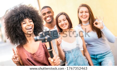 Millenial people taking video selfie with stabilized mobile phone  - Happy friends having fun on new tech trends - Youth friendship concept with guys an girls sharing moments on social media networks