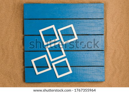 Blue wood and sea sand with mockup photo frames. space to write. Top view