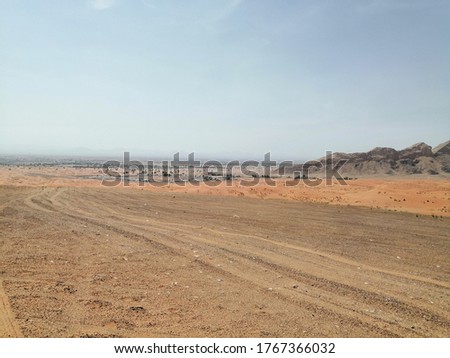 Beautiful and pristine desert sand dunes with semi-arid native plants in Sharjah, United Arab Emirates, Middle East. Wind action constantly changes the shape, height and size of the sand dunes.