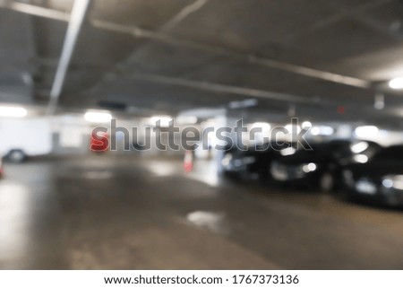 Blurred cars in car parking lot in shopping mall.