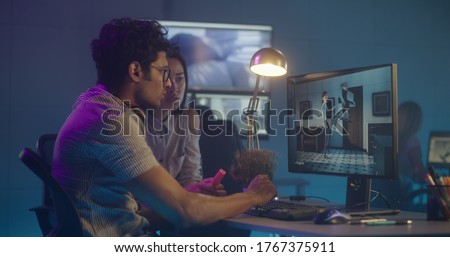 Medium shot of two artist discussing over animation Royalty-Free Stock Photo #1767375911