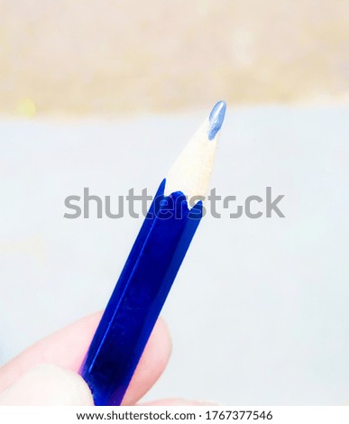 Blue colour pencil on a blurry background.