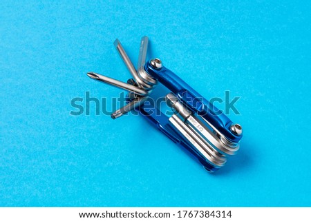 Multitool for repair and maintenance of a bicycle on a blue background. Service concept. Universal tool for pulling threaded connections