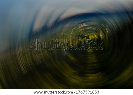 Abstract, subtly-colored, slanted, fully-rotational motion-blurred, green landscape with sonic boom type effect