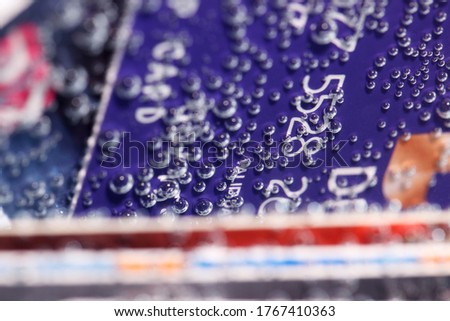 sinking credit card in water with abstract bubble background