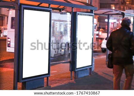 Advertising vertical billboard in the city glows at night. MOCKUP for design