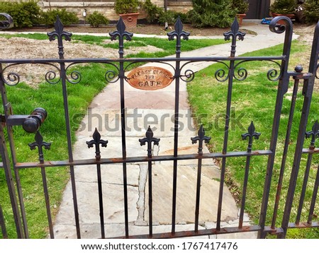 Old iron gates with sign  please close the gate
