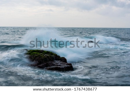 beauty moss area and small island on sunshine at the beach with magic light and violently wave of sea