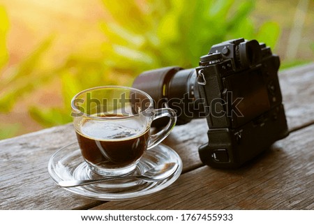 Morning coffee with a camera on an old wooden table, coffee and nature
