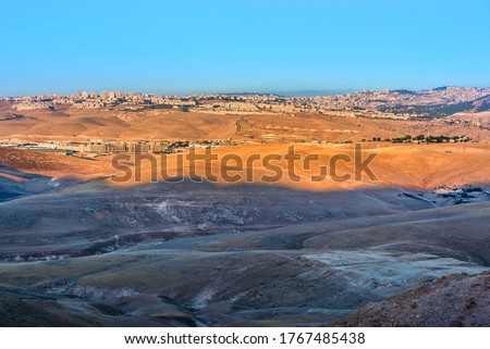 Panorama of the Israeli city of Ma'ale Adumim, Arab village of Bethany/Al-Azariya on the Mount of Olives, the construction site of the new shopping center, and bedouin camp nestled in the desert hills