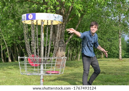 The smiling young man throws the disc golf disc