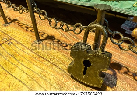 The retro large padlock, made of iron, was placed on the floor of the room.