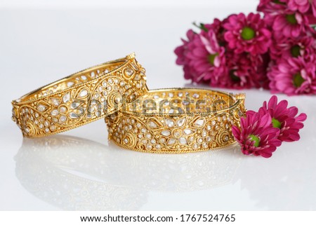 Indian traditional wedding jewellery, bangles with pink flowers on white background. selective focus Royalty-Free Stock Photo #1767524765
