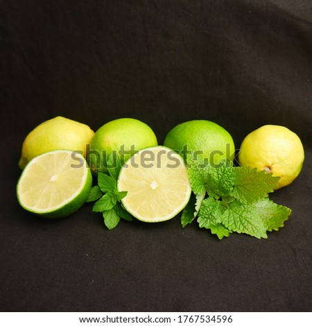 lime, lemon, leaves on a black background