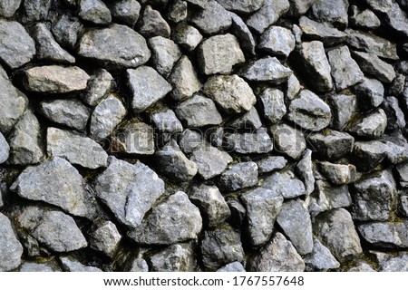 Rocks wall background. Stones wall texture. Artificial waterfall made with natural grey stones. Outdoor nature.