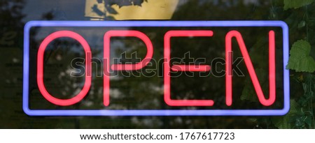 A blue and red neon Open sign in the window of a store