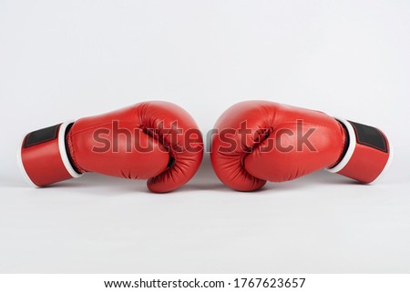 The concept of power, wrestling, competition - red boxing gloves lie opposite each other on a light background
