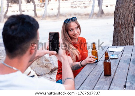 group of friends take photos with smartphone in a picnic area