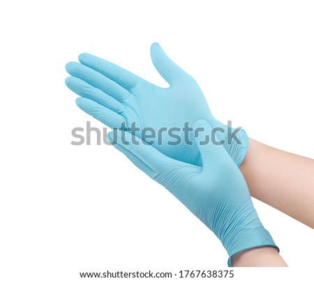 Medical nitrile gloves.Two blue surgical gloves isolated on white background with hands. Rubber glove manufacturing, human hand is wearing a latex glove. Doctor or nurse putting on protective gloves Royalty-Free Stock Photo #1767638375