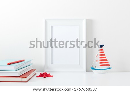 Summer composition. Travel concept. White frame mockup in interior with sea elements on white wall background. Template frame for text. Poster mockup.
