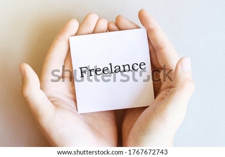 white paper with text Freelance in male hands on a white background