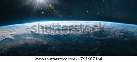 Ultra wide wallpaper of Earth in the outer space. Orbit of planet. Sun light and stars on background. Elements of this image furnished by NASA
