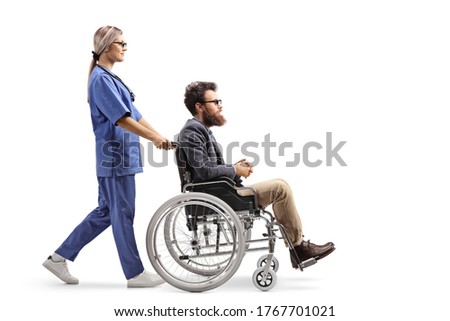 Full length profile shot of a female nurse pushing a disabled man in a wheelchair isolated on white background 