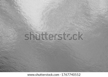 Silver foil texture background with highlights and uneven surface Royalty-Free Stock Photo #1767740552