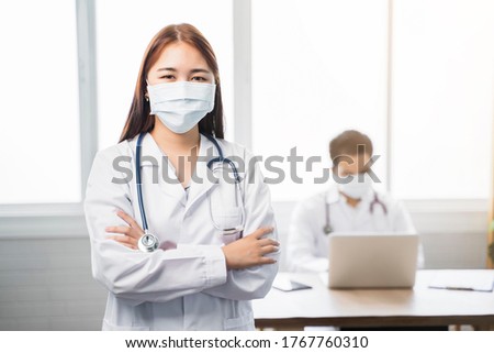Medical healthcare Asian doctor woman with colleague teamwork working together examine diagnosing discuss arm crossed wearing surgical mask stethoscope work at home modern office isolated background