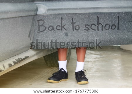 School boy legs and Write the word back to school on the car door. The after covid-19 concept