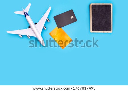 a plane, credit cards, and a sign on a blue background. Photo for calculating the cost of travel, flight tickets for holidays