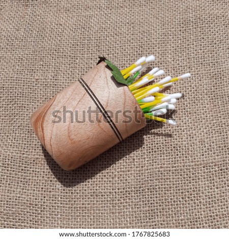 Cotton buds isolated in woonden jar on the jute fabric background