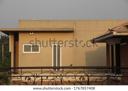 Side view of a house with light sun rays glimmering their shade on it at dawn time.