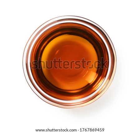 Sesame oil in a glass bowl set against a white background Royalty-Free Stock Photo #1767869459