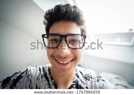 Teenage boy with glasses taking selfie Royalty-Free Stock Photo #1767886058